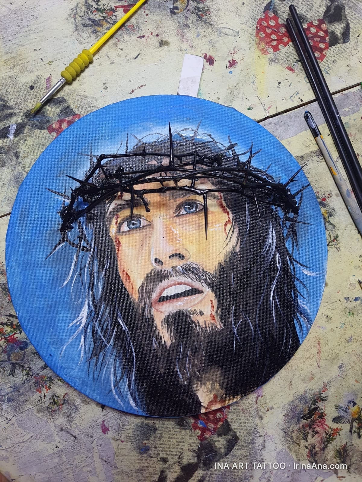Portret de bărbat cu barbă și păr lung, purtând o coroană de spini, pe un fundal albastru. Expresia este de suferință.