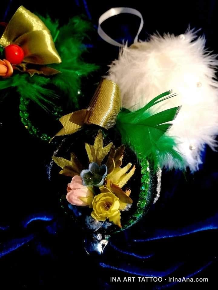 Trei ornamente de Crăciun în formă de cap de Mickey Mouse. Unul e alb și pufos, altul are o fundă aurie și frunze verzi, iar…