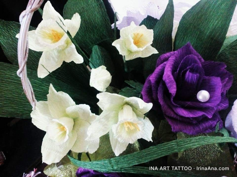 Crepe paper flower arrangement featuring white daffodils and a purple rose adorned with a pearl.