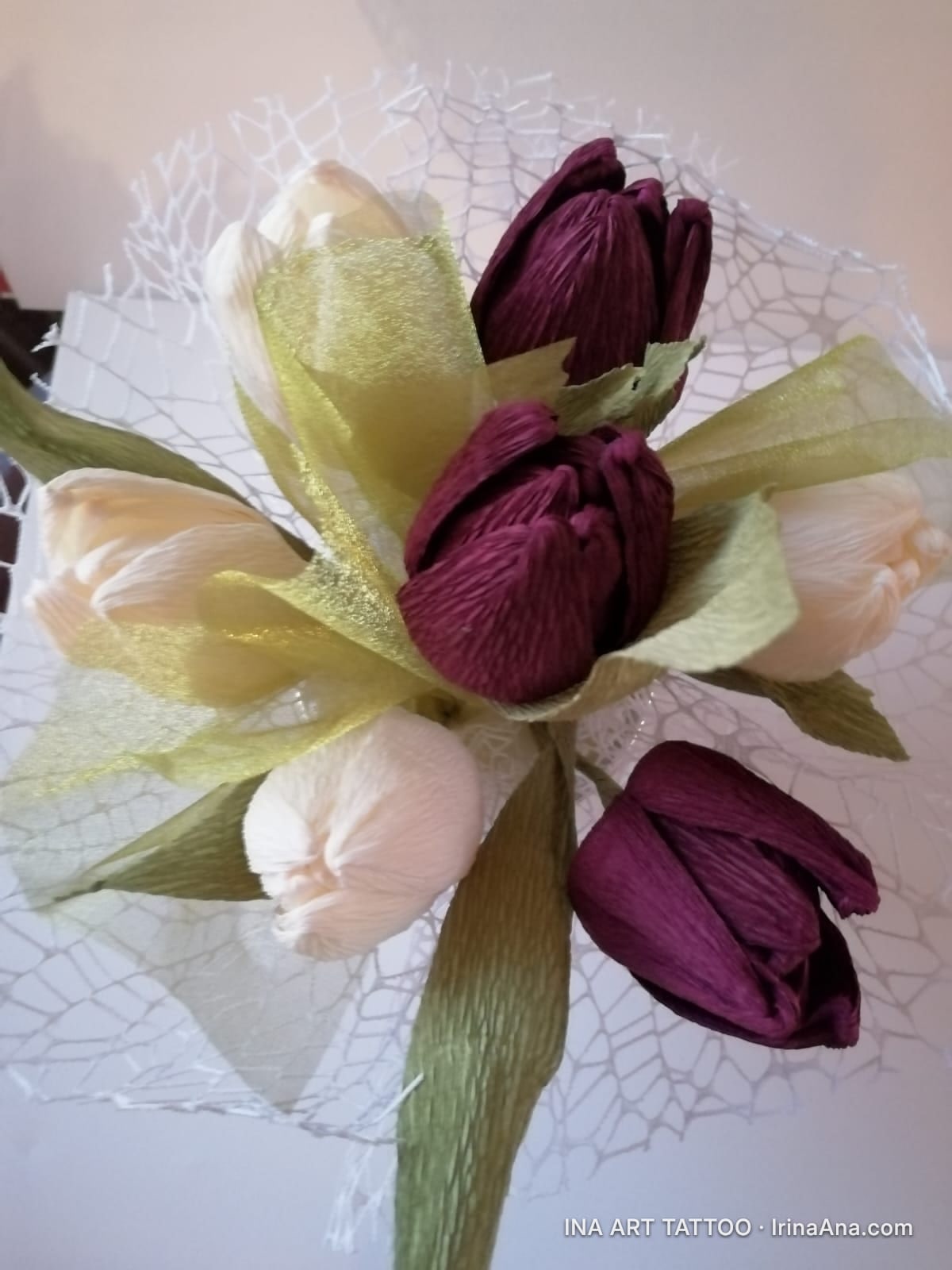 Bouquet of white and maroon crepe paper tulips, wrapped in white decorative mesh.