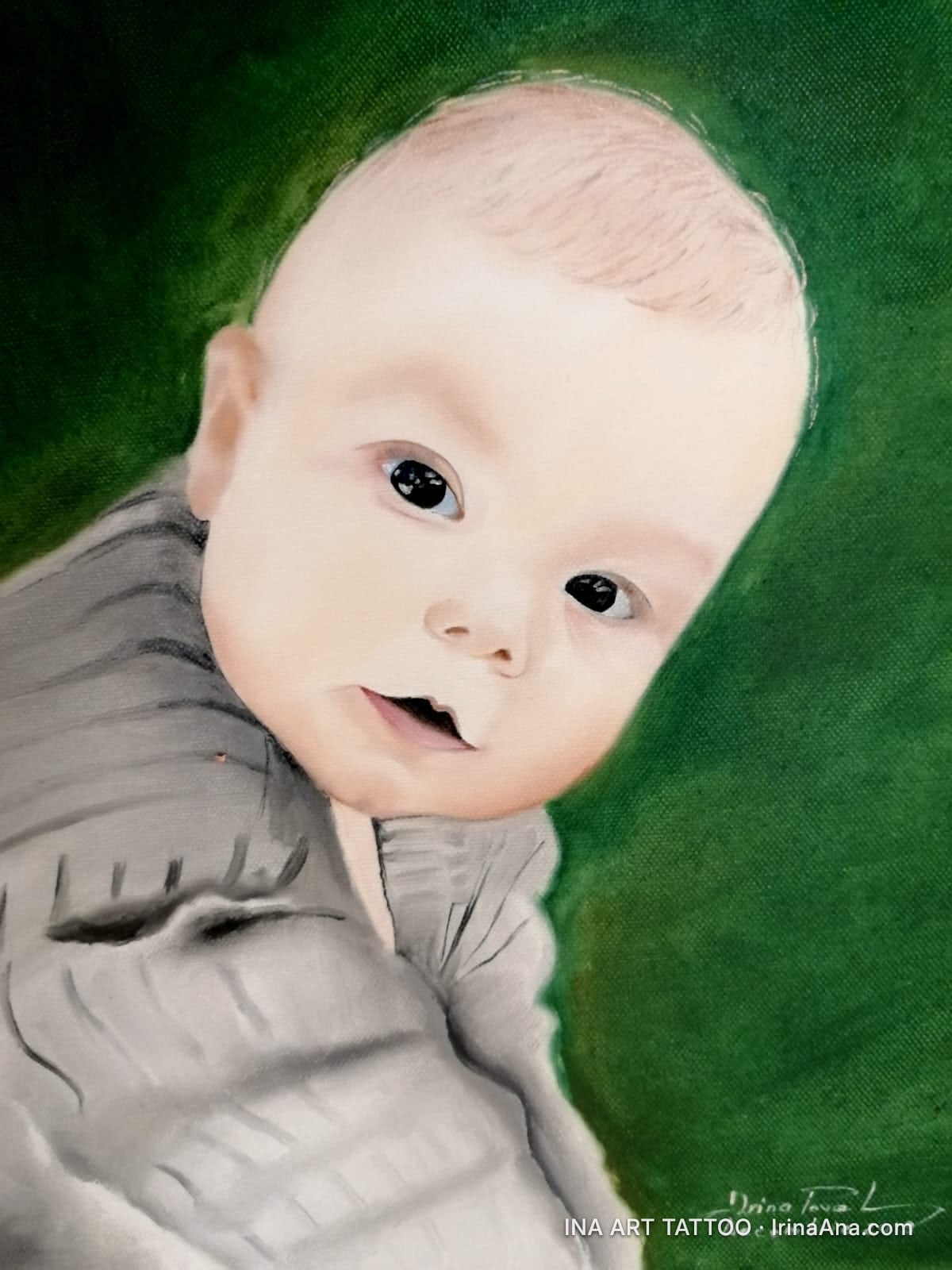 Portrait of a baby with large eyes, curious gaze, against a dark green background. Wearing a gray shirt.