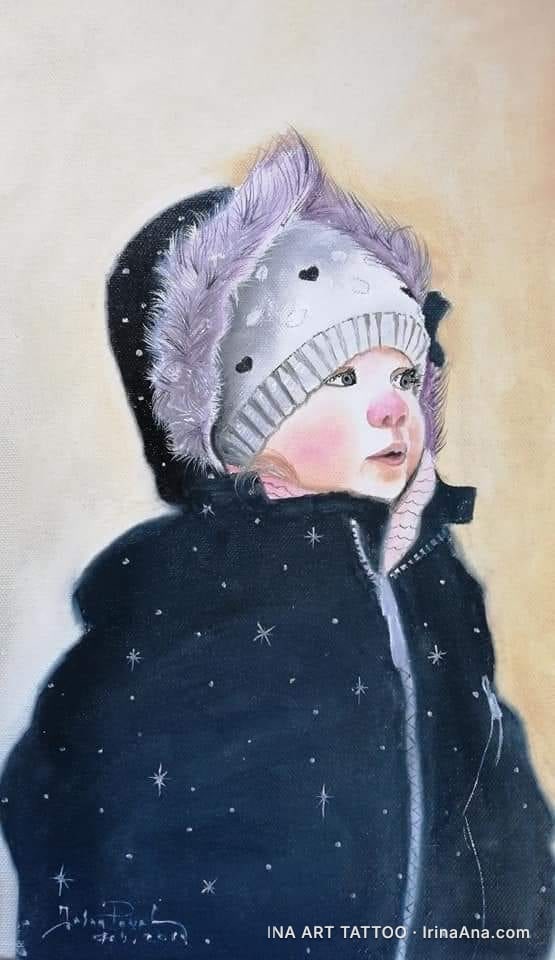 Portrait of a child wearing a white hat with hearts, a fur-lined hood, and a black jacket with white stars.