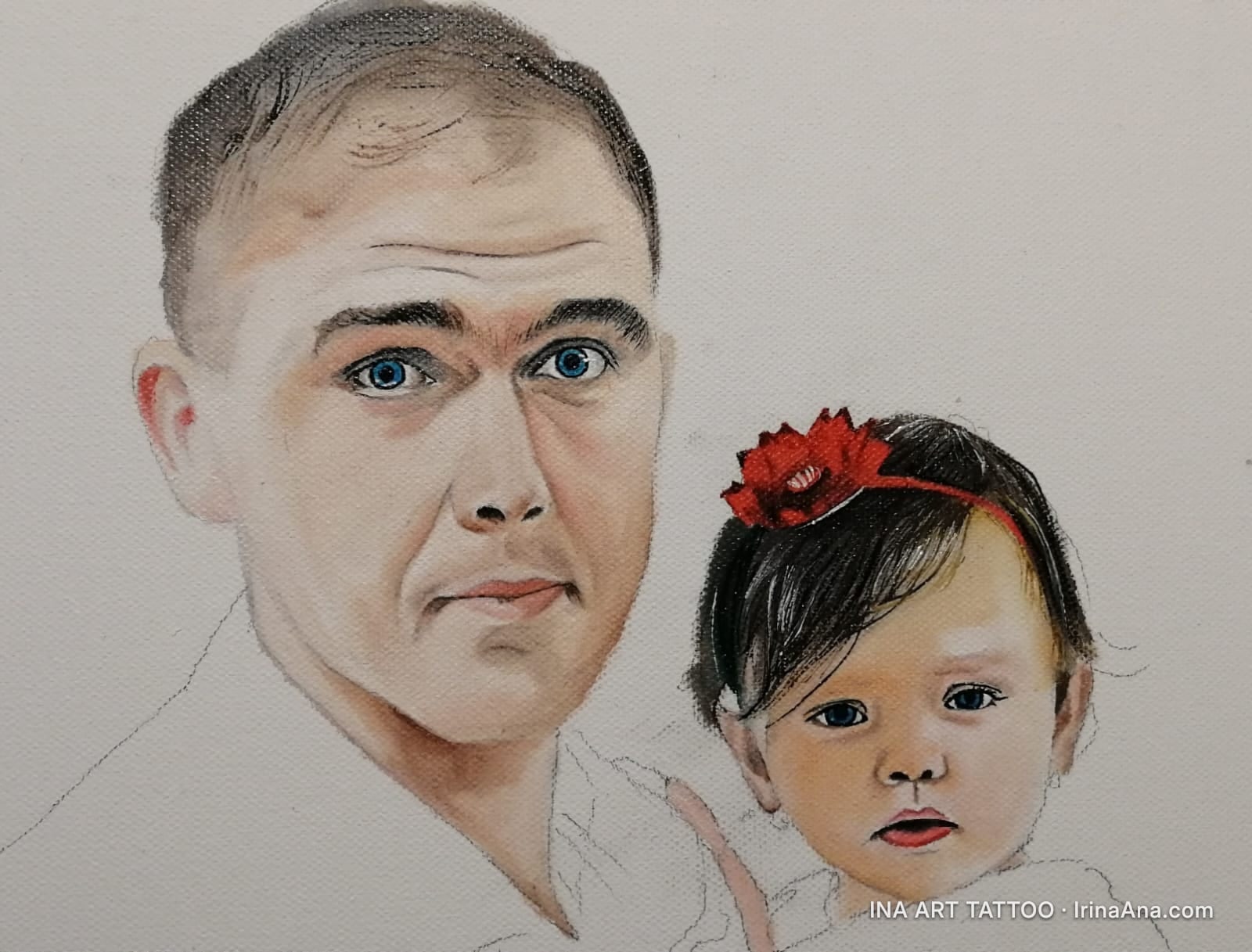Portrait of a man holding a baby girl with a red headband. The baby has dark hair and blue eyes.