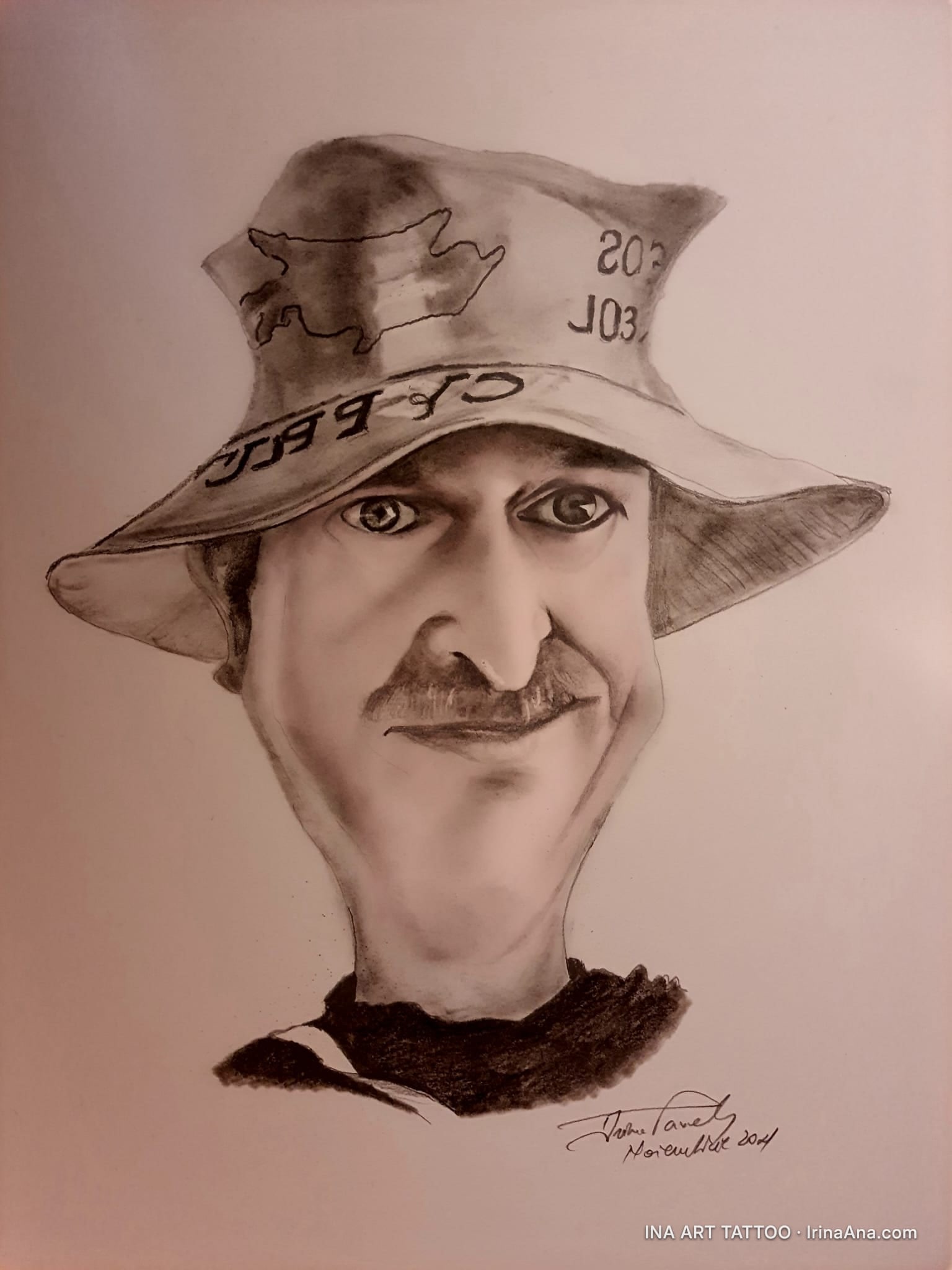 Pencil caricature of a man with a mustache, wearing a fishing hat with a drawn pig and the text 203 J03.