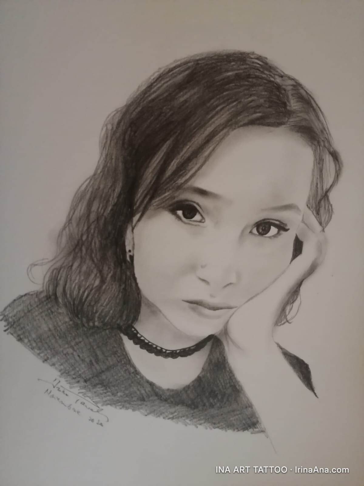Portret creion al unei tinere cu păr închis la culoare, sprijinindu-și bărbia în mână, privind înainte.