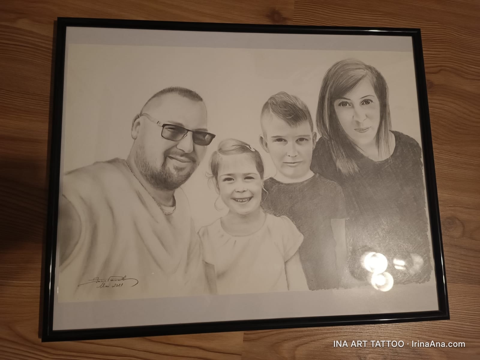 Portret în creion al unei familii: un bărbat cu barbă și ochelari, o femeie și doi copii, o fată și un băiat. Toți zâmbesc.