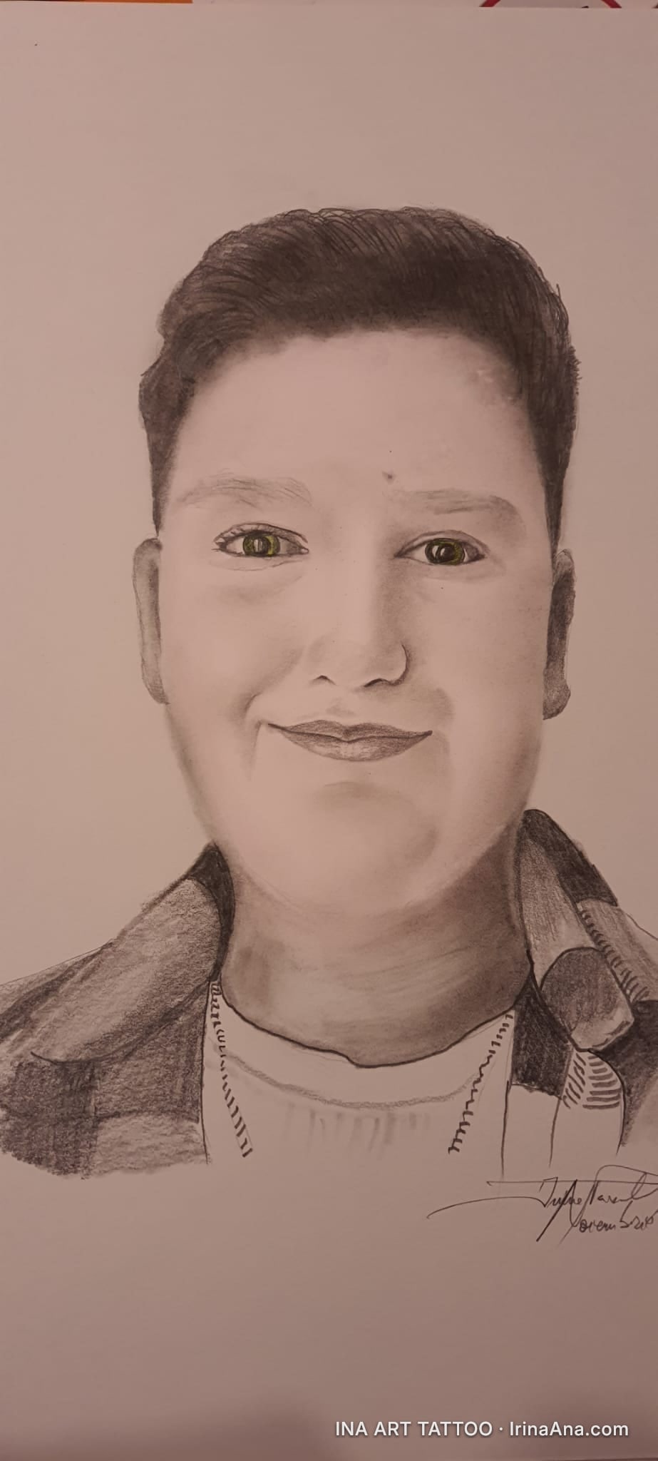 Portret în creion al unui băiat zâmbitor, cu păr șaten închis și ochi verzi, purtând o cămașă în carouri.