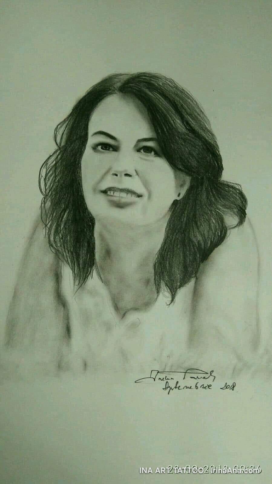 Portret în creion al unei femei cu păr lung, închis la culoare, zâmbind ușor și privitor la dreapta.